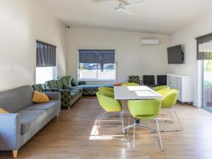 sala de estar con sofá, mesa y sillas en NRMA Echuca Holiday Park, en Echuca