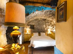a bedroom with a bed and a stone wall at Agriturismo Al Marnich in Schignano