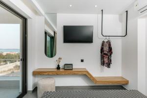 OPSIS Suites في يميناريا: غرفة معيشة مع تلفزيون على الحائط