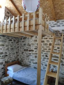 a bunk bed in a room with a stone wall at Stone House in Këlcyrë