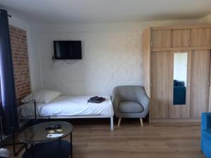 um pequeno quarto com uma cama e uma cadeira em Leon's Rooms em Żary