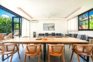 ein Esszimmer mit einem großen Holztisch und Stühlen in der Unterkunft New 5br Villa, Enclosed Lounge, Canggu Oasis in Canggu