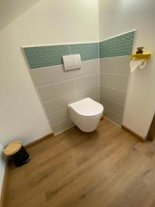 a bathroom with a white toilet and a wooden floor at Le Lys Écossais in Aubigny-sur-Nère