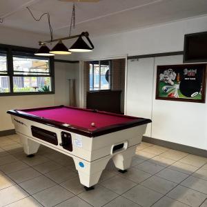 - une table de ping-pong dans une pièce avec un haut violet dans l'établissement Jambin hotel motel, 