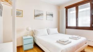 a white bedroom with a bed and a window at Italianway Comfort - Salasco 18 in Milan