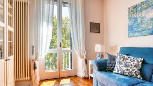 een woonkamer met een blauwe bank en een groot raam bij Italianway - Monte Nero 63 in Milaan
