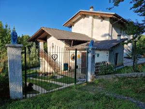 einen Zaun vor einem Haus mit einem schwarzen Hund in der Unterkunft Casa Omnia B&B in Castellamonte