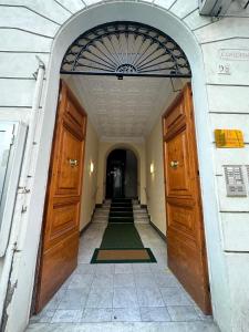wejście do budynku z dwoma drewnianymi drzwiami w obiekcie Baltik Guesthouse w Rzymie