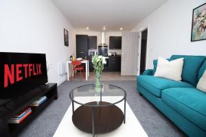 a living room with a blue couch and a table at New Modern 1 Bedroom Apartments - Prime Location - By EKLIVING LUXE Short Lets & Serviced Accommodation - Cardiff in Cardiff