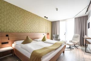 una camera da letto con un letto e una scrivania in una stanza di Novotel Karlsruhe City a Karlsruhe