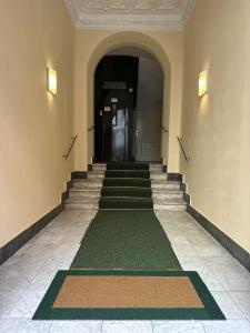 un pasillo con escaleras y alfombra verde en Baltik Guesthouse, en Roma