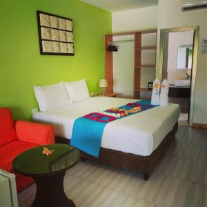 a bedroom with two beds and a red chair at Nadi Fancy Hotel in Nadi