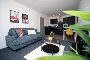 uma sala de estar com um sofá e uma mesa em New Modern 1 Bedroom Apartments - Prime Location - By EKLIVING LUXE Short Lets & Serviced Accommodation - Cardiff em Cardiff