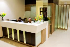 two people sitting at a reception desk in a room at O Hotel in Ahmadnagar
