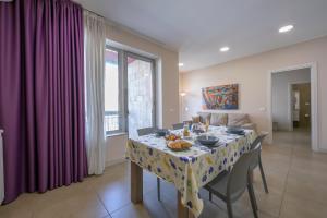 comedor con mesa y mantel en Palazzo dei Delfini Apartments - Happy Rentals, en Catania