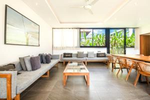 ein Wohnzimmer mit einem Sofa und einem Tisch in der Unterkunft New 5br Villa, Enclosed Lounge, Canggu Oasis in Canggu