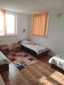 a room with two beds and a rug on the floor at Ваканционни къщи'На брега' Holiday houses ON THE COAST in Varna City