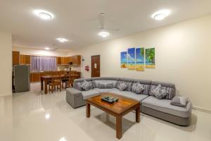 a living room with a couch and a table at Sahaj Holiday Apartments in Baie Sainte Anne