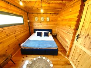 Un dormitorio con una cama en una cabaña de madera. en Spokojny zakątek, en Silice