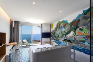 a bedroom with a large painting on the wall at Hotel Montemare in Positano