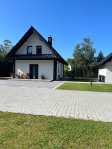 a house with a brick driveway in front of it at Dom na Borówkowym Wzgórzu in Paleśnica