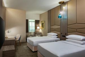 杜拜的住宿－Four Points by Sheraton Production City, Dubai，酒店客房,配有两张床和椅子