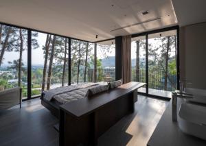 a bedroom with a large bed and large windows at Tam Dao Retreat Venuestay in Tam Ðảo +10 photos