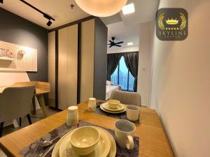 une salle à manger avec une table et de la vaisselle dans l'établissement The Colony Skyline Suites KLCC, à Kuala Lumpur