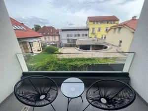 a view of a balcony with two chairs and a table at Rezidencia Kmeťova so súkromným parkovaním zdarma, 5 min pešo do centra in Košice +3 photos