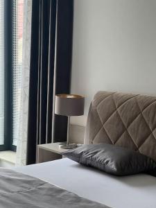 a bed with a pillow and a lamp on a table at Rezidencia Kmeťova so súkromným parkovaním zdarma, 5 min pešo do centra in Košice