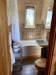 a bathroom with a tub and a sink at Le chalet des coeurs in Le Tholy