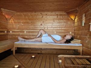a woman is laying in a sauna at Lotse 01 in Neustadt in Holstein