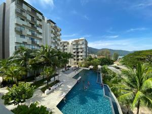 an overhead view of a swimming pool with palm trees and buildings at By The Sea@Side Seaview n swimming pool view #133A in Batu Ferringhi