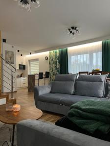 a living room with a couch and a table at Dom na Borówkowym Wzgórzu in Paleśnica