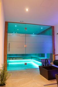 - une piscine dans une pièce dotée d'un mur en verre dans l'établissement Aida Apart, à Nauders