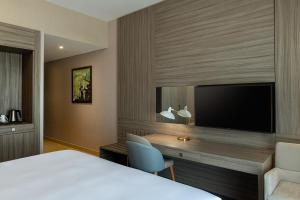 una camera d'albergo con letto, scrivania e TV di Four Points by Sheraton Production City, Dubai a Dubai