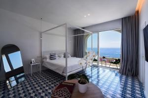 فندق Montemare في بوسيتانو: غرفة نوم مع سرير وإطلالة على المحيط