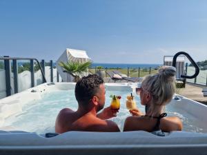 a man and a woman sitting in a hot tub at Lotse 03 in Neustadt in Holstein