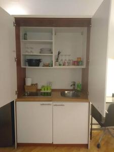 a kitchen with white cabinets and a sink at Apartment Rahela in Zagreb