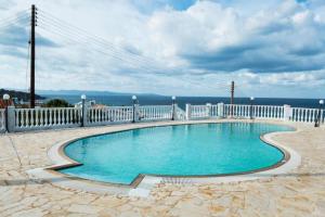 una piscina con una valla blanca alrededor en Seaclusion Vacation Villa, en Pomos