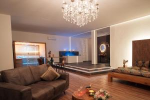 un soggiorno con un divano e un lampadario di Privat-Spa mit Whirlpool und Sauna in Sursee a Sursee