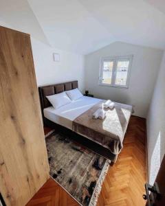 ein Schlafzimmer mit einem großen Bett und Holzboden in der Unterkunft Spacious One bedroom Apartment DIA in Budva
