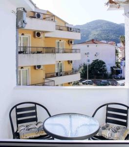 einen Tisch und Stühle auf einem Balkon mit einem Gebäude in der Unterkunft Spacious One bedroom Apartment DIA in Budva