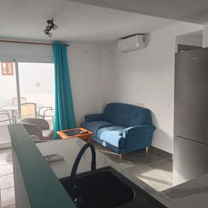 a living room with a blue couch and a table at Duquesa Harbour Club Aparthotel in Manilva