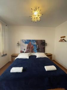 a bedroom with a large blue bed with two towels on it at La Catrina Hostel in San Miguel de Allende