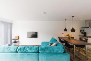 een woonkamer met een blauwe bank en een tafel bij 2 bedroom luxury beach apartment Millendreath in Saint Martin