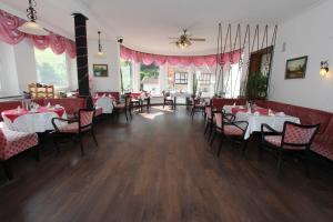 uma sala de jantar com mesas e cadeiras e cortinas cor-de-rosa em Hotel Glück Auf & Bürgerkeller em Bad Grund