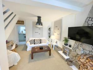 a living room with a couch and a tv at Cottage by Rhigos Mountains in Treherbert