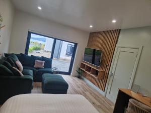 a living room with a couch and a tv at Sea View Studio in Buncrana