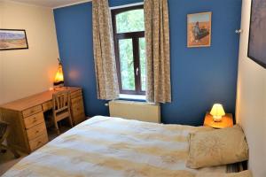 Schlafzimmer mit einem Bett, einem Schreibtisch und einem Fenster in der Unterkunft Au Randonneur - B&B in Thuin